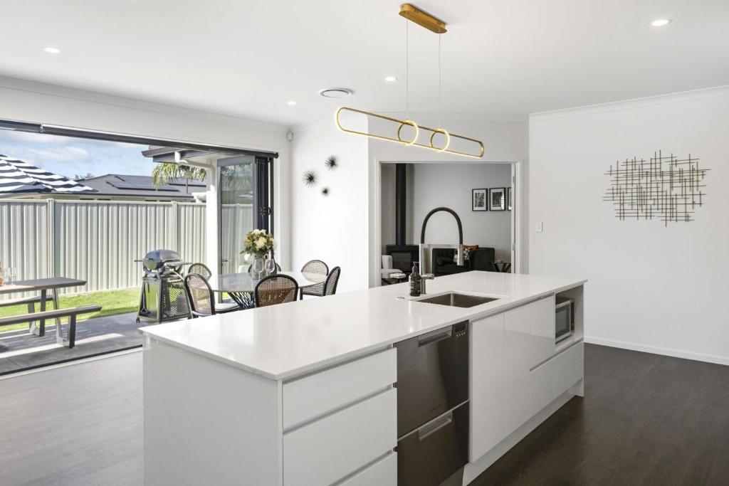 a kitchen with white countertops and a dining room at Havelock Holiday House in Havelock North