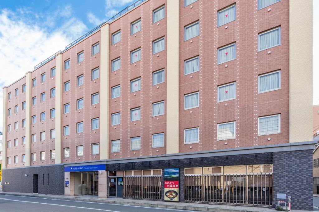 un gran edificio de ladrillo rojo en una calle en HOTEL MYSTAYS Fukuoka Tenjin Minami, en Fukuoka