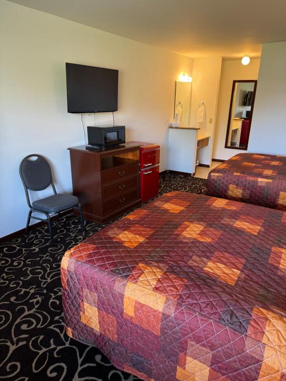 a hotel room with two beds and a flat screen tv at Malibu Inn in Wisconsin Dells