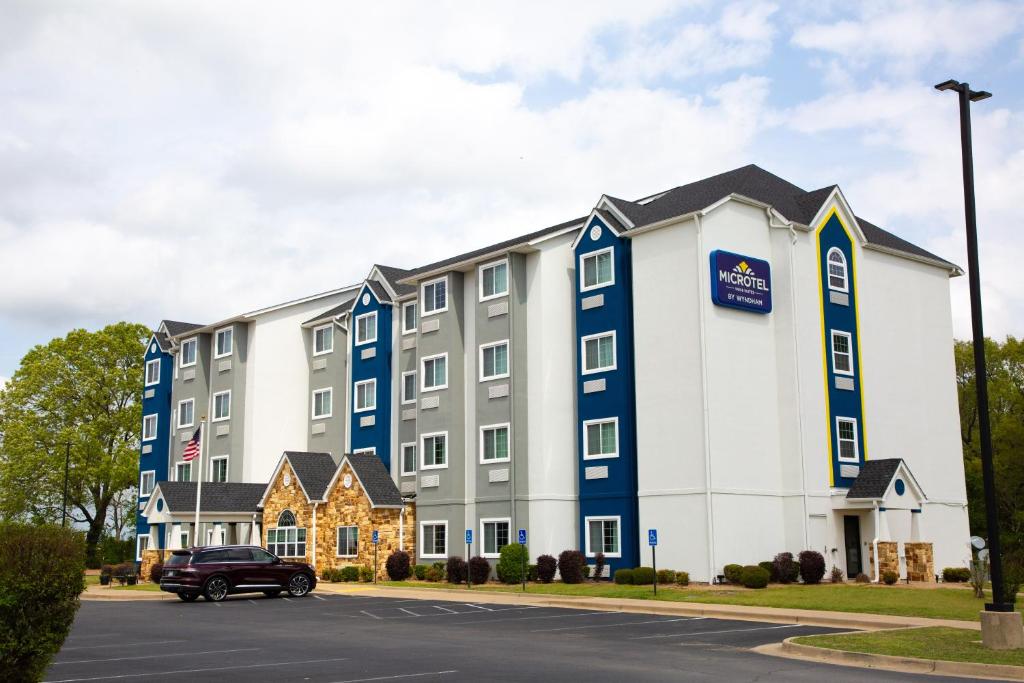 a building with a car parked in front of it at Microtel Inn & Suites by Wyndham Searcy in Searcy