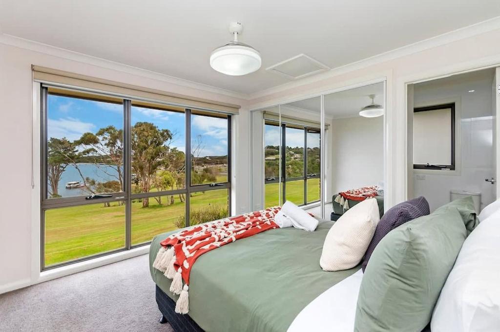 a bedroom with a bed and a large window at Hopkins View Holiday Home in Warrnambool