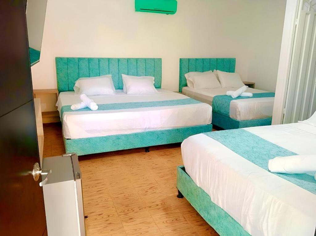 a bedroom with two beds with blue and white at Hotel Pallara Campestre in Ricaurte