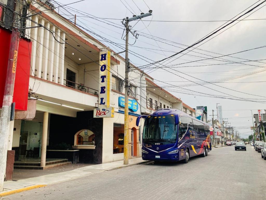 Un autobús azul está estacionado en una calle de la ciudad en Hotel Rex Ciudad Valles en Ciudad Valles