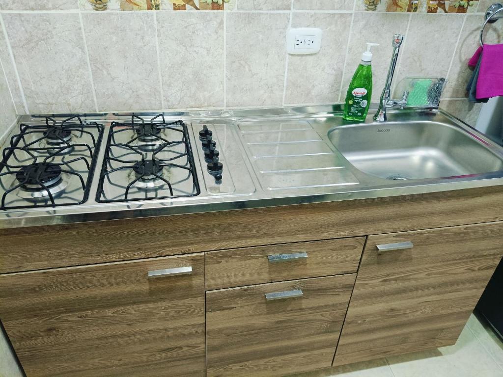 a kitchen counter with a stove and a sink at Suite Hermosa ven descansa o trabaja El Rodadero Santa Marta in Gaira