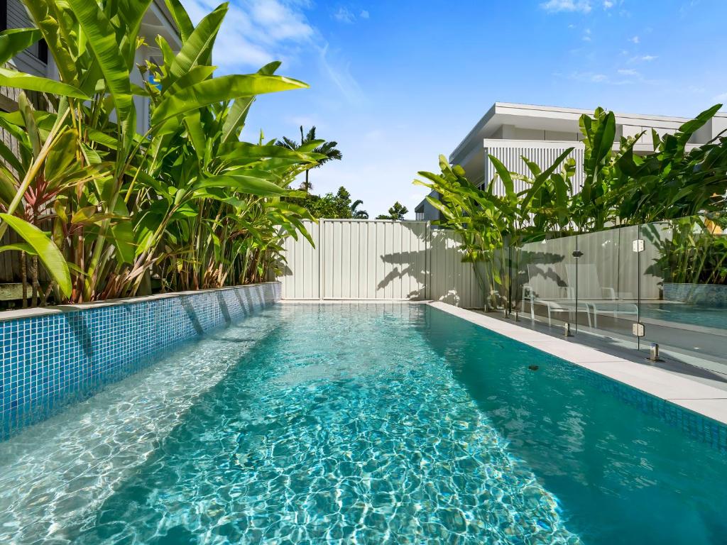 a swimming pool with blue water in front of a building at Noosa Dreaming in Noosa Heads