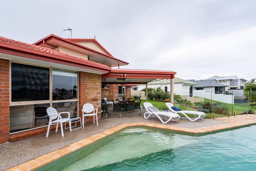 a house with a swimming pool next to a house at Waterfront BNB in Gold Coast