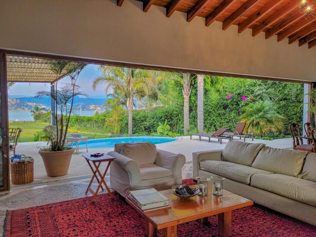a living room with a couch and a table and a pool at Villas Valle in Valle de Bravo
