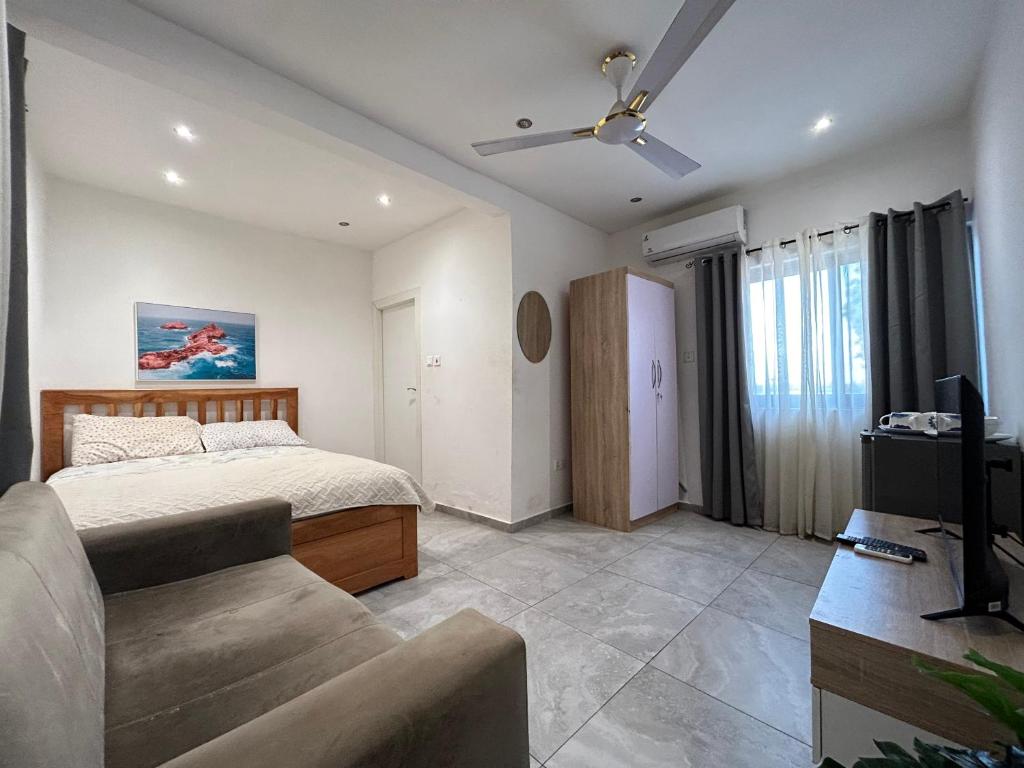 una camera da letto con un letto e un divano di Dabs Apartments a Accra