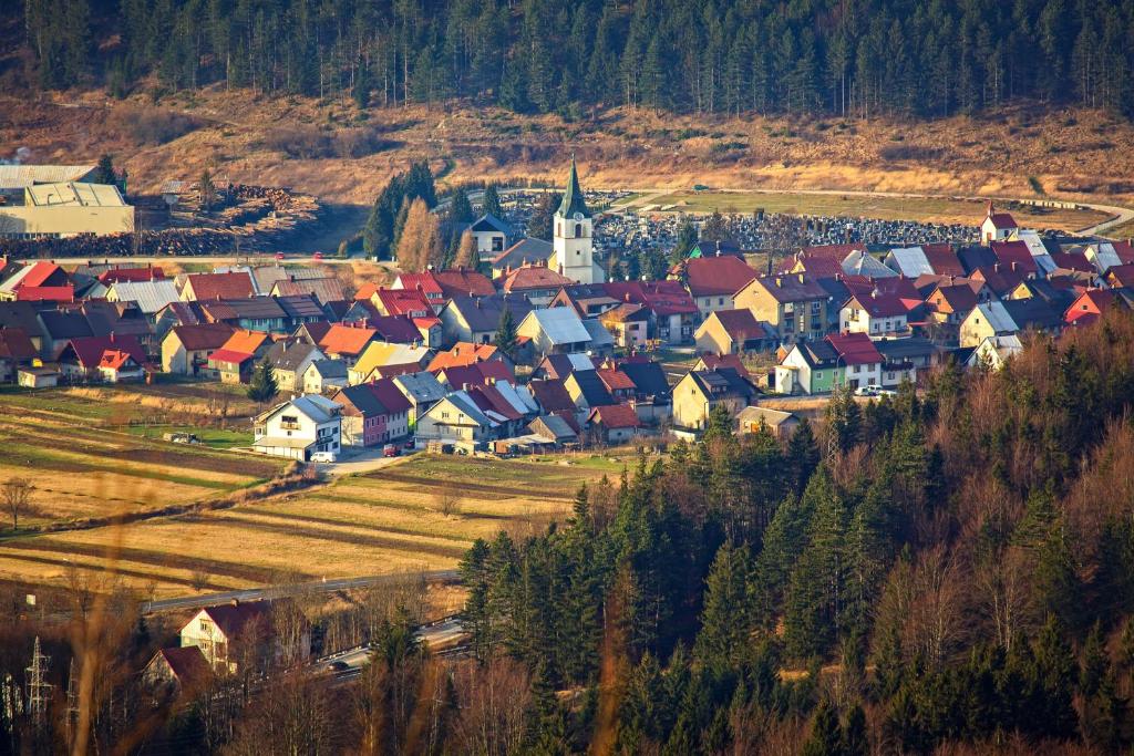 a group of houses in a town with a church at Apartments for families with children Delnice, Gorski kotar - 21746 in Delnice