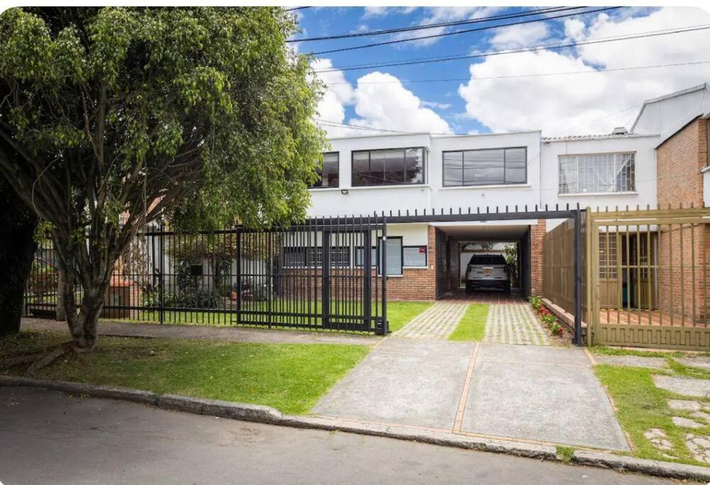 een groot wit huis met een poort en een oprit bij Enorme Casa Campestre en Bogotá in Bogota