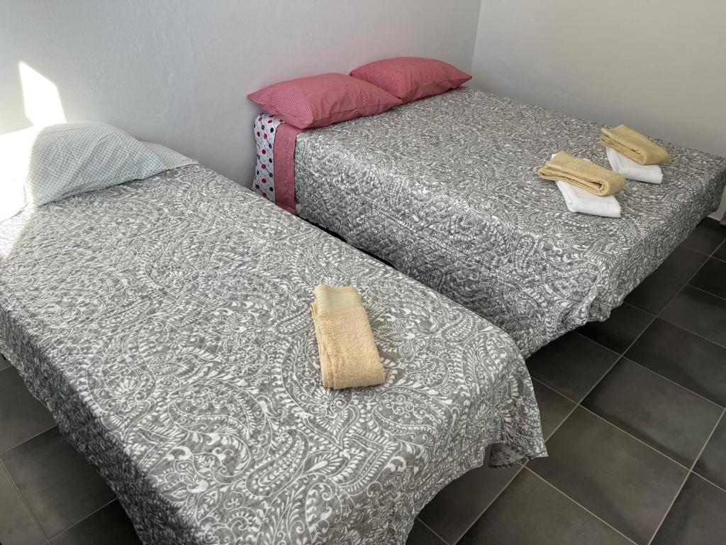 twee bedden naast elkaar in een kamer bij ESTANQUEIRA GUEST HOUSE in Sines