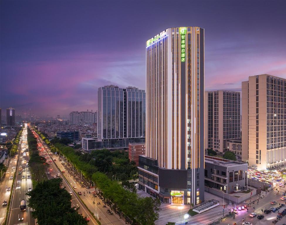 um horizonte da cidade com um edifício alto e tráfego em Holiday Inn Express Guangzhou Panyu Dashi, an IHG Hotel em Guangzhou