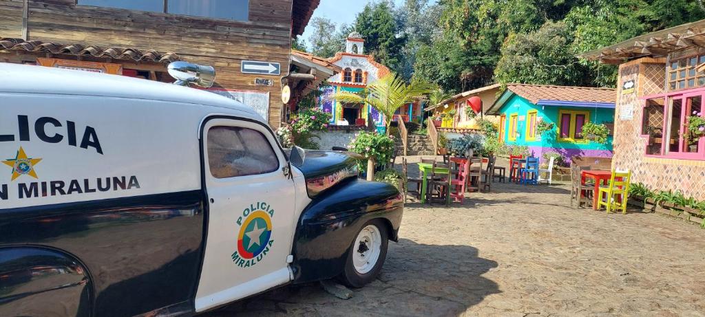 uma carrinha branca estacionada em frente a uma aldeia em Miraluna em Medellín