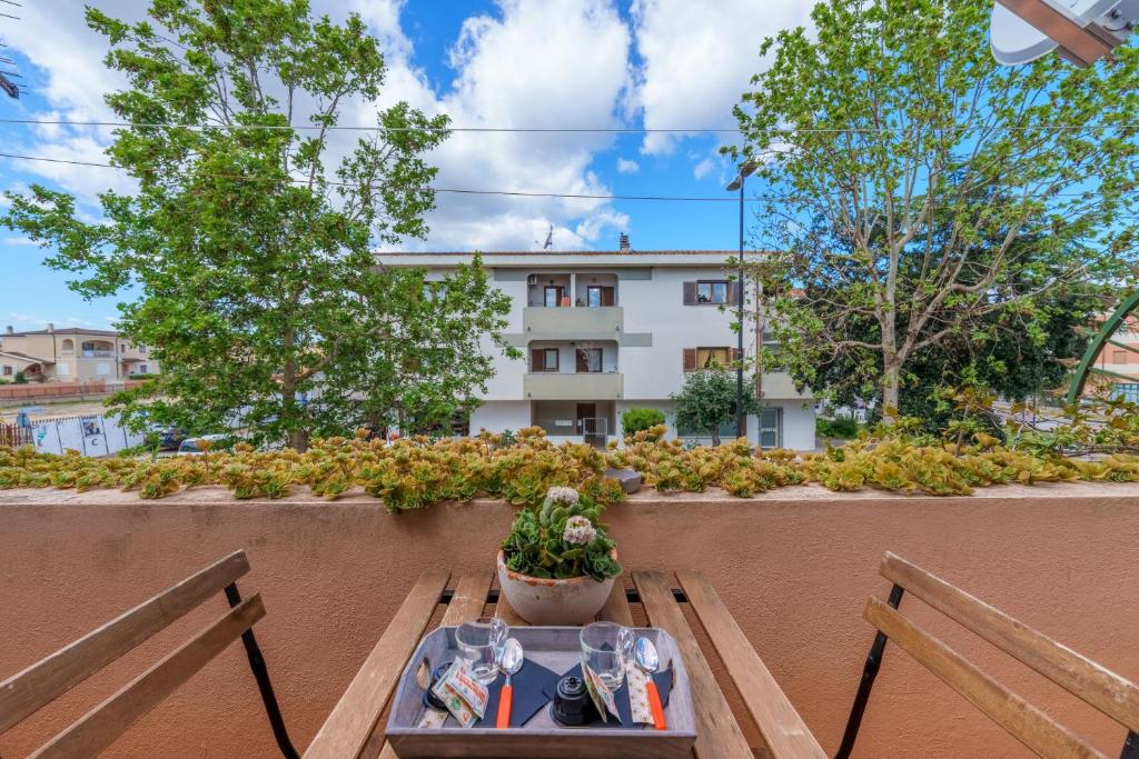 una mesa con una planta en un balcón con un edificio en Casa La Rocca, en Olbia