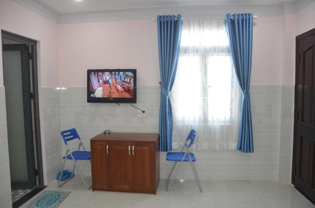 a room with two chairs and a desk and a television at hotel Hương Thiên Phú in Dĩ An