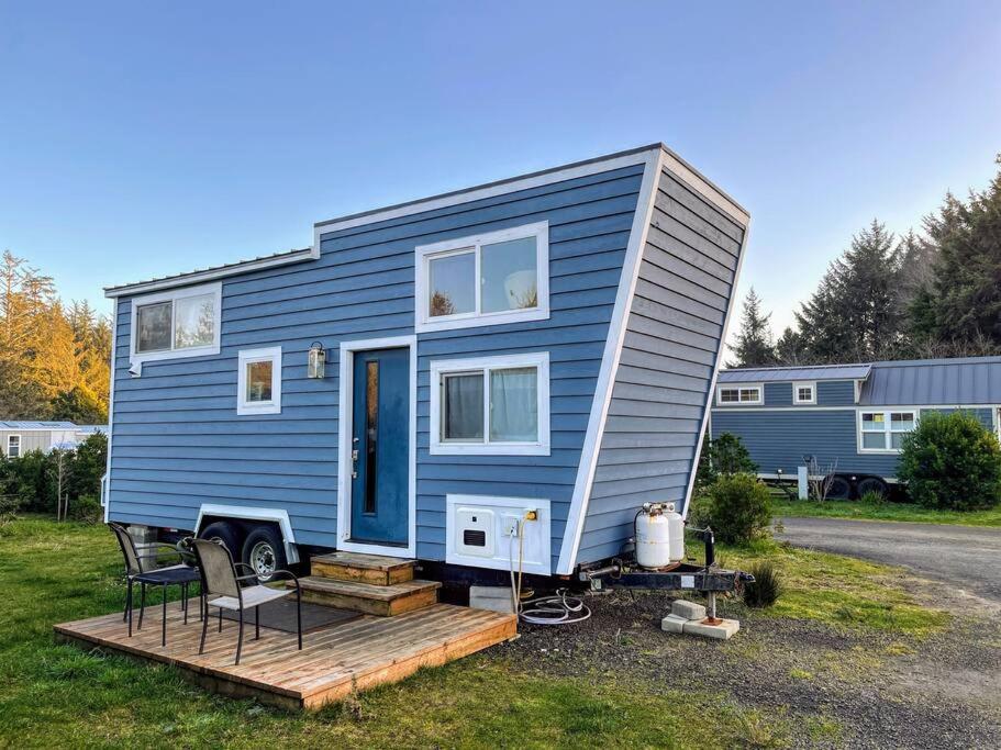 a blue tiny house sitting on a wooden deck at Breakers - stay in a tiny home on the Oregon Coast in Waldport