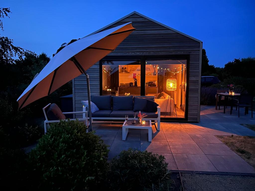 einen Pavillon mit einem Sofa und einem Regenschirm in der Unterkunft Marina Strandbad Wellness-Chalet Romantik Haus Nr 411 in Olburgen