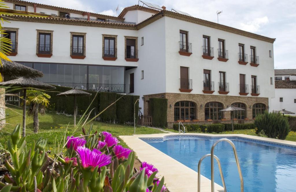 dom z basenem i fioletowymi kwiatami w obiekcie Aparthotel Rural 12 Caños w mieście Galaroza