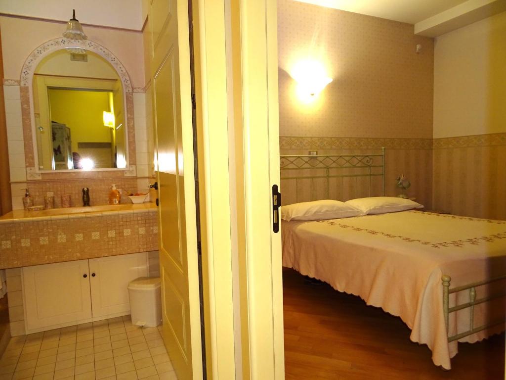 sypialnia z łóżkiem, umywalką i lustrem w obiekcie Villa Gioia Rooms w mieście Montegranaro