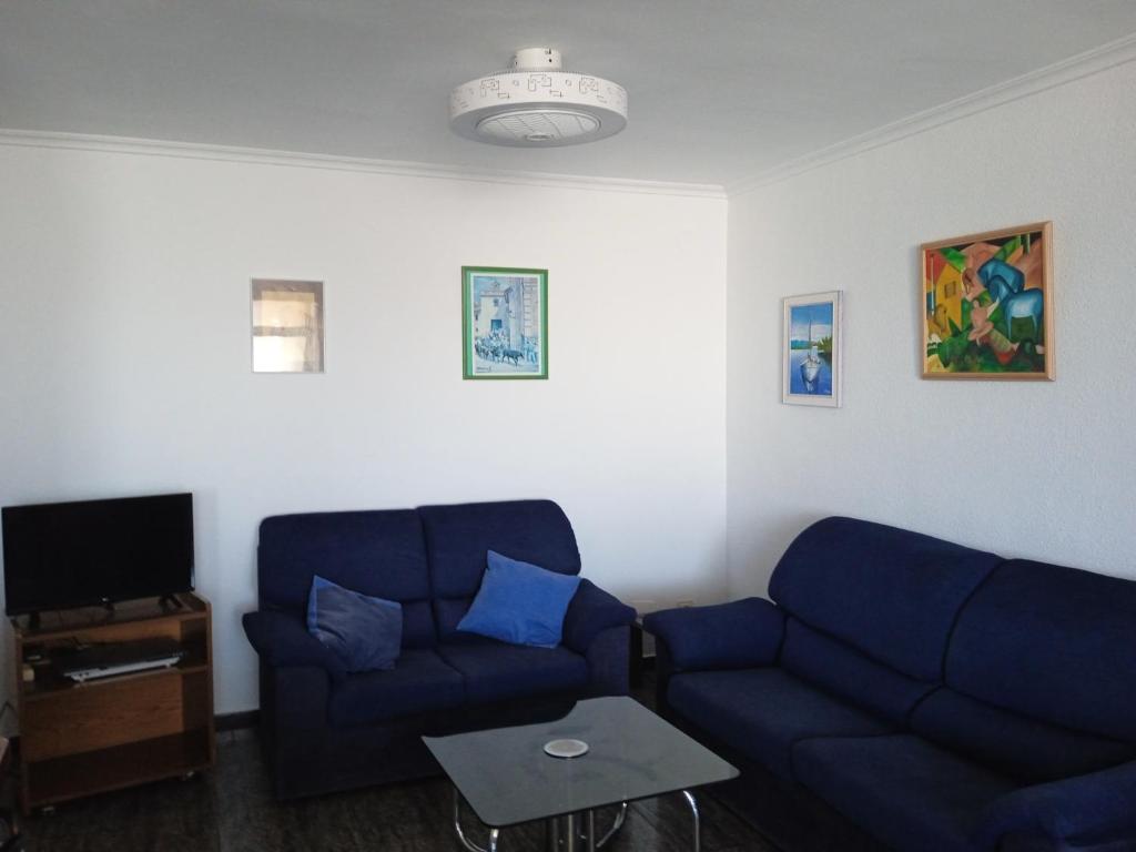 een woonkamer met twee blauwe banken en een tafel bij MARE NOSTRUM, PISCINA in Canet de Berenguer