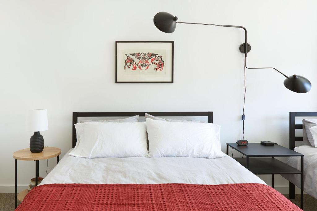 a bedroom with a bed with a red blanket at Snob Hollow Inn Downtown Anchorage in Anchorage