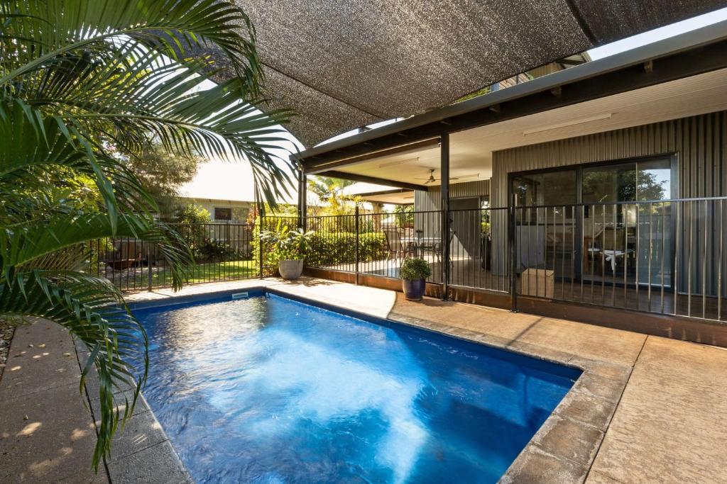 a swimming pool in front of a house at Pelcan Gardens Retreat in Broome