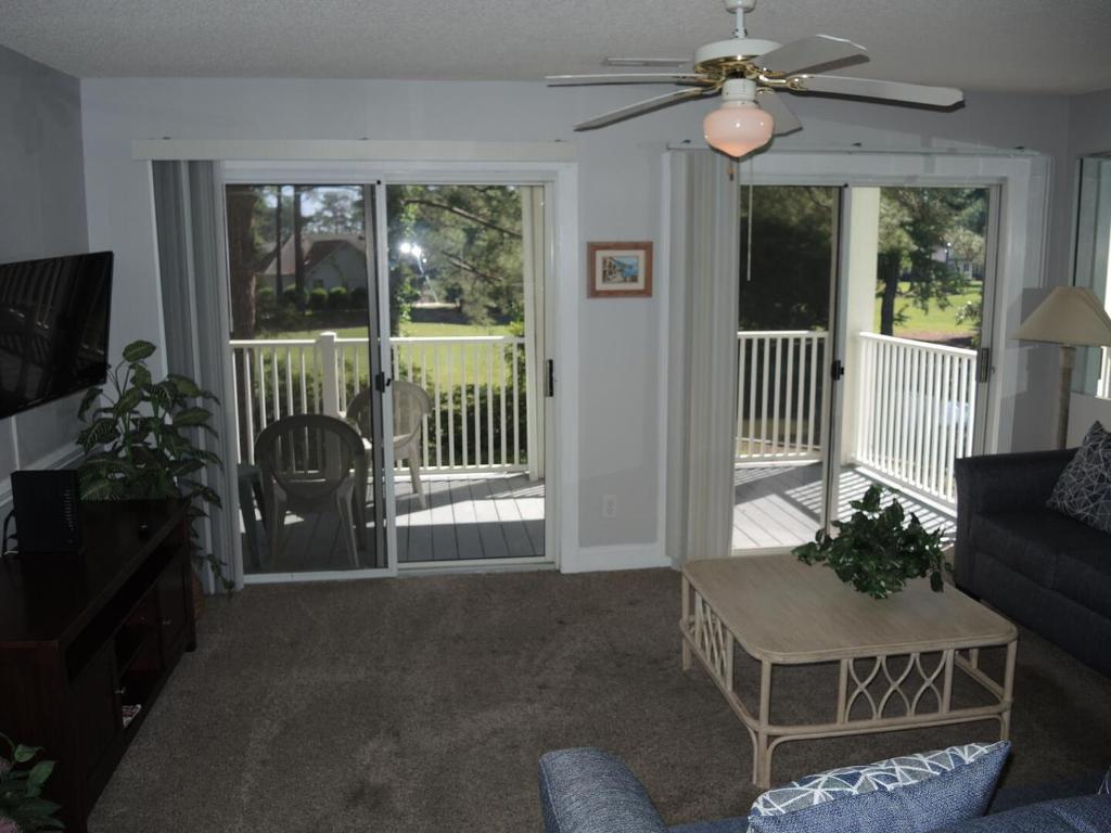 a living room with a couch and a screened in porch at 1005M condo in Calabash