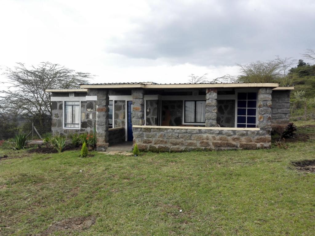 een stenen huis in een veld met een tuin bij Heaven's Gate in Nakuru