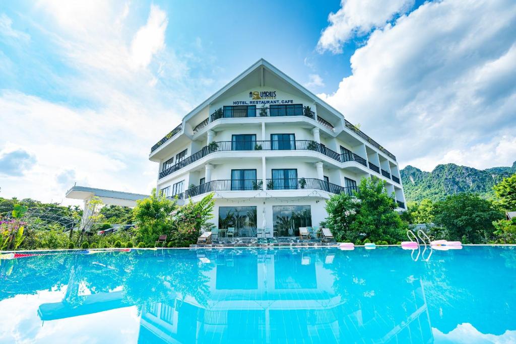 a hotel with a pool in front of it at KHÁCH SẠN AQUARIUSGARDEN VÂN LONG NINH BÌNH in Ninh Binh