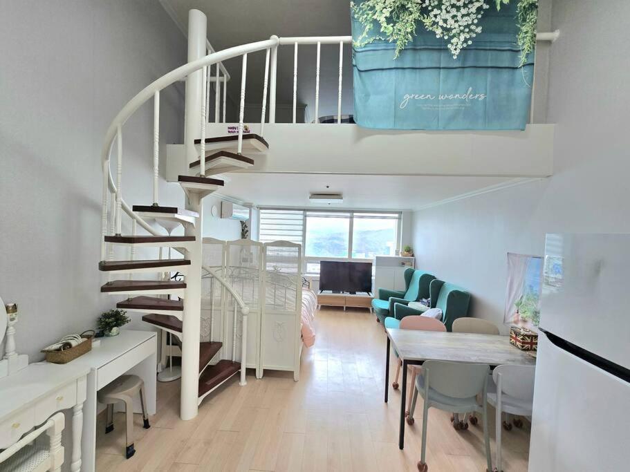 a living room with a spiral staircase in a house at Like U Residence in Goyang