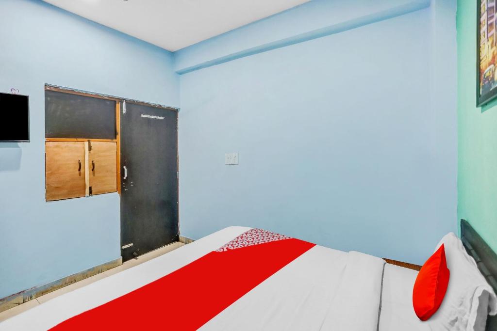 a bedroom with a bed with red pillows on it at Flagship Rk Residency Near Iskcon Temple Noida in Noida