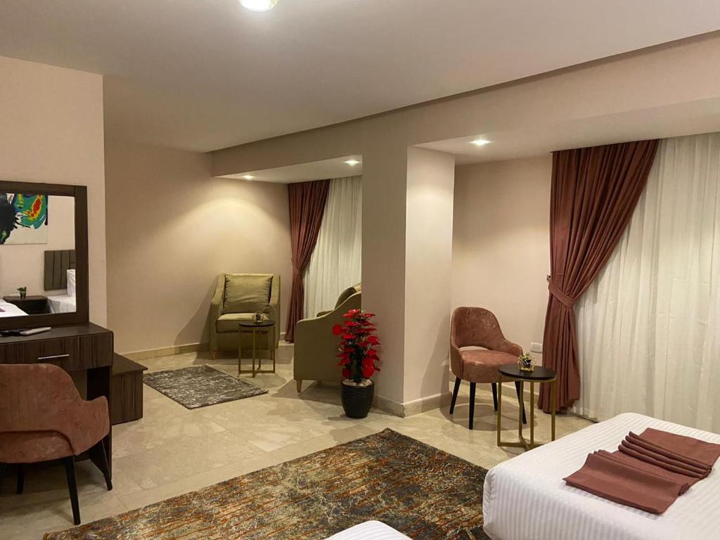 Habitación de hotel con cama y sala de estar. en Tuya Queen Pyramids View en El Cairo