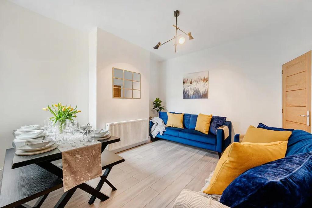 sala de estar con sofá azul y mesa en Pass the Keys Spacious Stylish House, en Mánchester