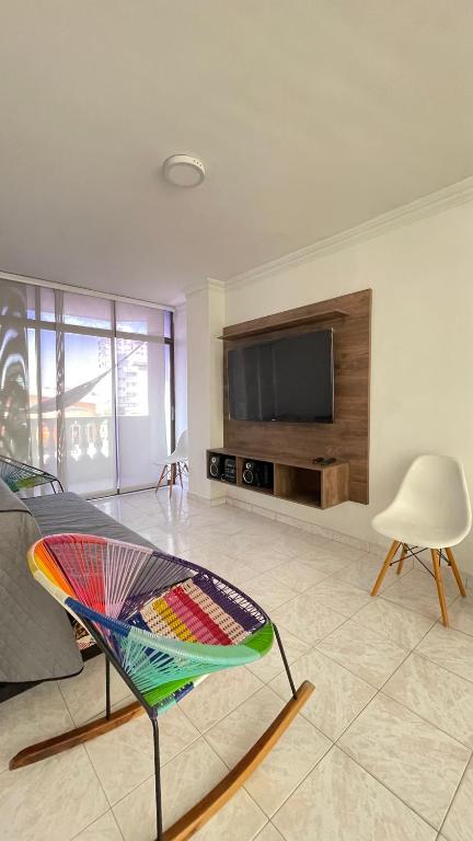 sala de estar con mesa y TV en apartamento Santa Marta-Rodadero Blanquita205, en Santa Marta
