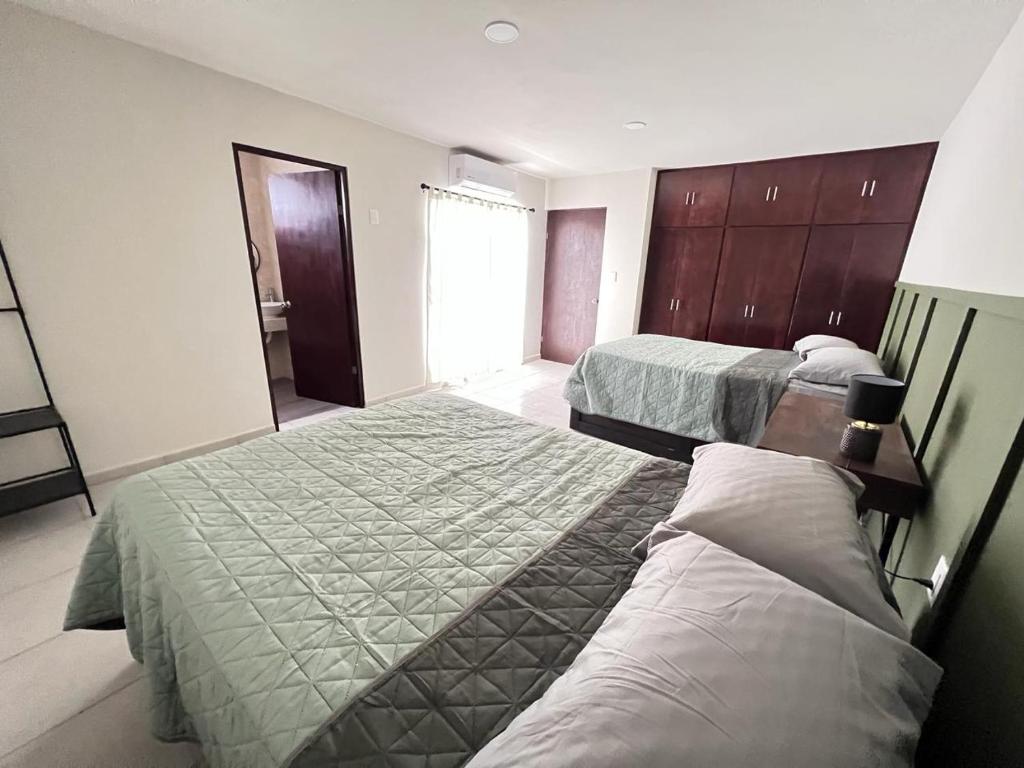 een hotelkamer met 2 bedden en een spiegel bij Casa Madero in Ciudad Madero