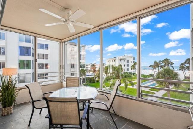 a balcony with a table and chairs and a large window at Island House Beach Resort 14N in Siesta Key