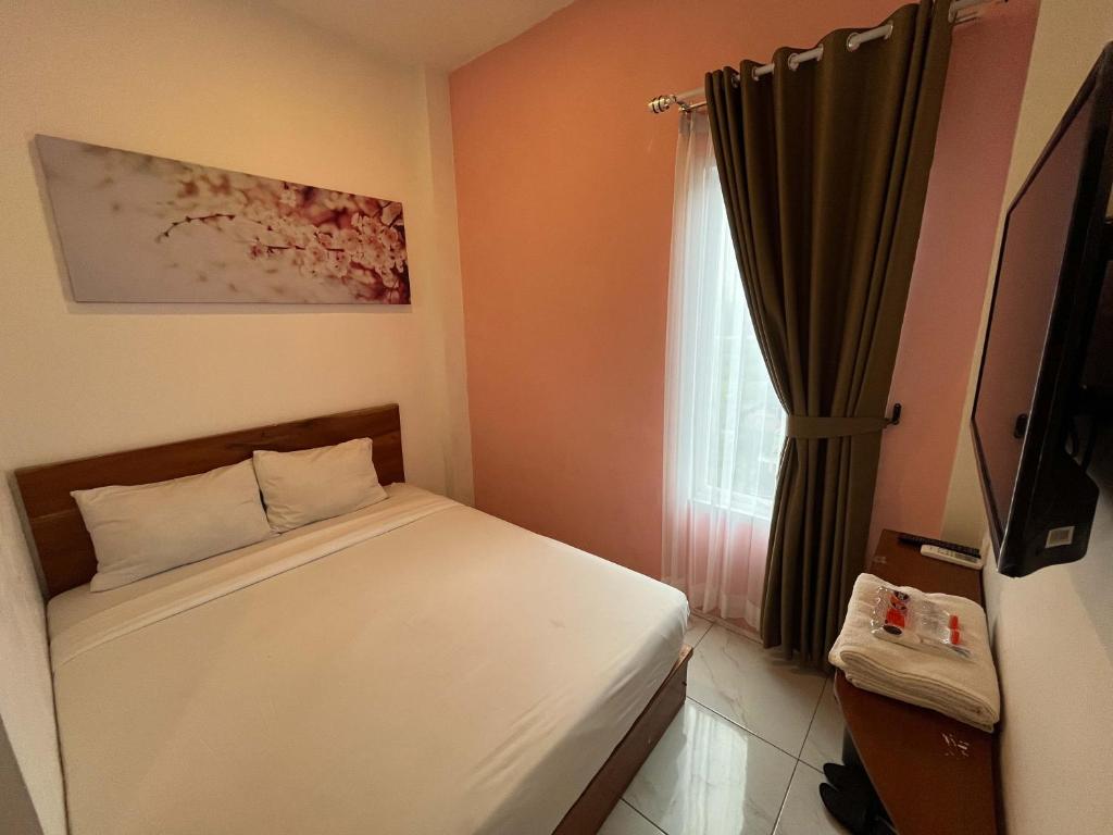 Habitación pequeña con cama y ventana en Rayana Resort Mitra Reddoorz, en Songgoriti