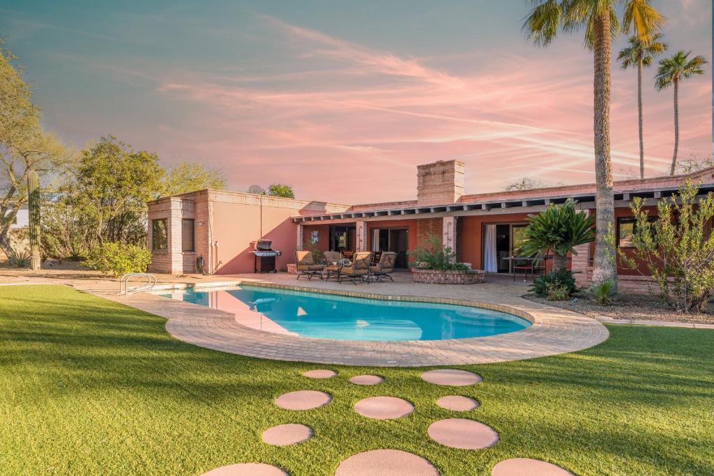 a backyard with a swimming pool and a house at La Casona by AvantStay Gorgeous Spanish Style Oasis w Historic Charm Pool in Phoenix