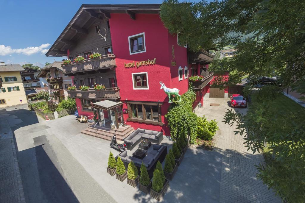 a red building with a restaurant on a street at Hotel Gamshof in Kitzbühel