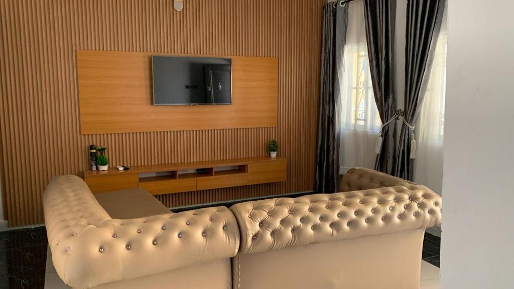 a living room with a couch and a tv at SHORT Rental in Ilorin