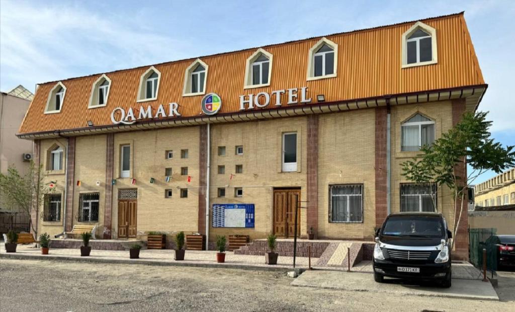 a hotel with a car parked in front of it at Qamar Hotel in Bukhara