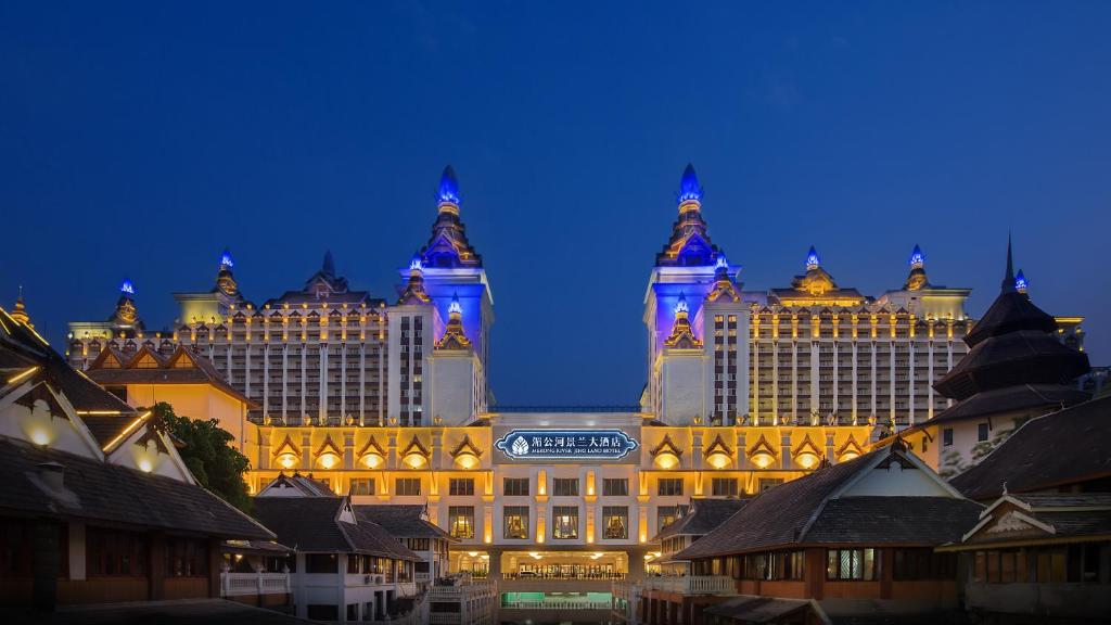 a large building with blue lights on it at night at Mekong River Jing Land Hotel in Jinghong