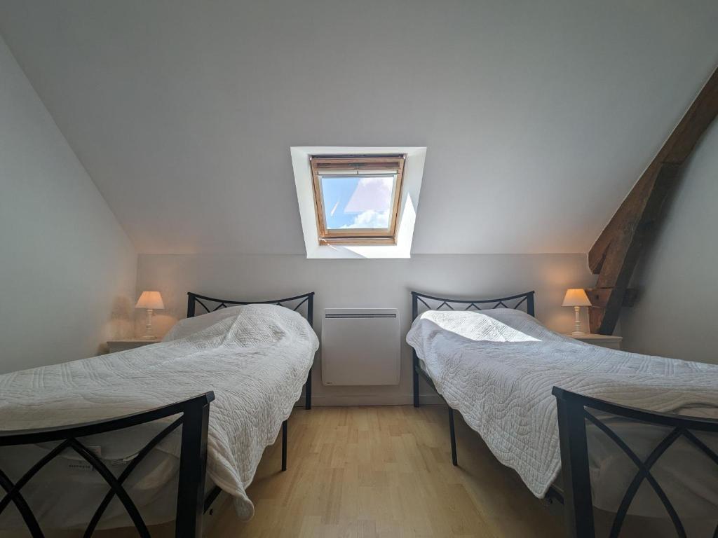 twee bedden in een kamer met een raam bij Gîte Frédille, 3 pièces, 4 personnes - FR-1-591-235 