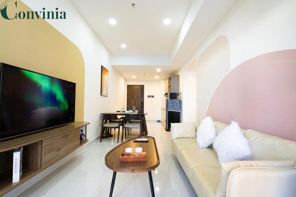 een woonkamer met een bank en een flatscreen-tv bij Soho Apartment By Convinia in Ho Chi Minh-stad
