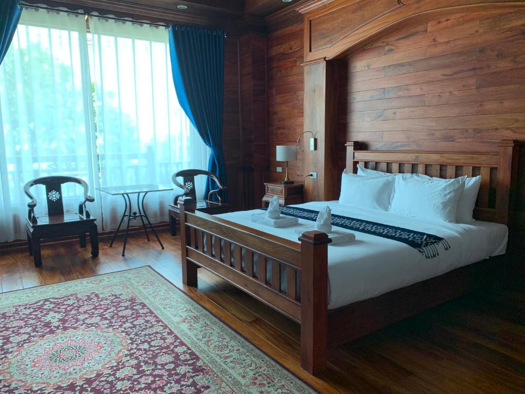 a bedroom with a large bed with a wooden wall at HotelLaoMixay in Savannakhet