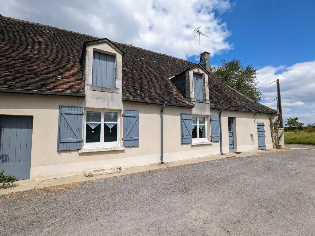 una antigua casa blanca con ventanas azules y entrada en Gîte Argy, 3 pièces, 6 personnes - FR-1-591-253, en Argy