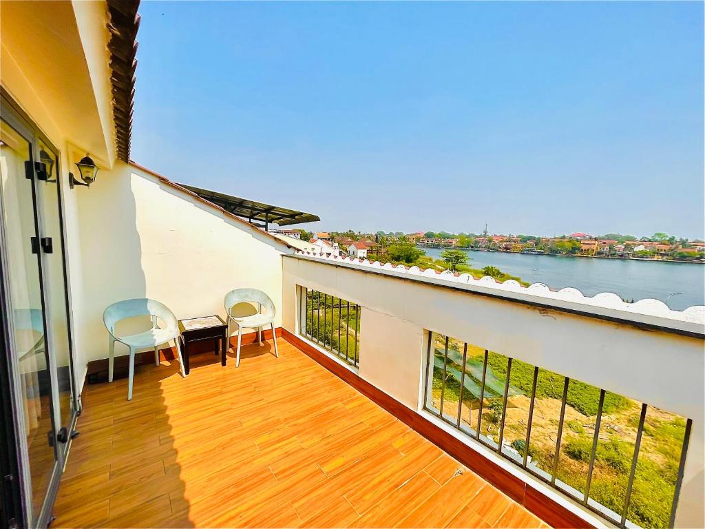 einen Balkon mit Stühlen und Blick auf das Wasser in der Unterkunft Thuong Da Riverside Homestay in Hoi An