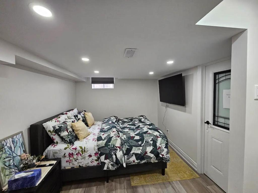 a bedroom with a bed and a tv in it at One Bedroom Apartment in Ajax