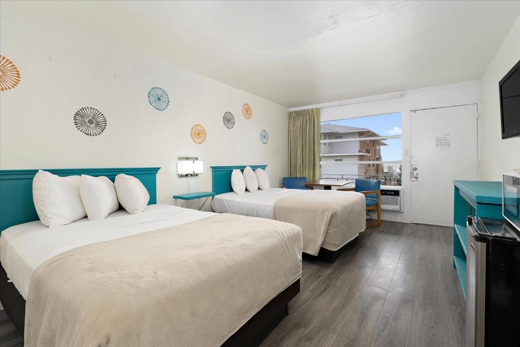 um quarto de hotel com duas camas e uma televisão em Eden Roc Ocean Side em Ocean City