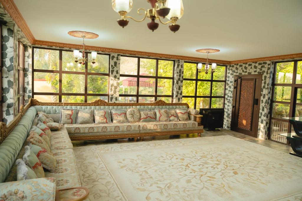 a living room with a couch and some windows at Alsalam Farmhouse in Hatta
